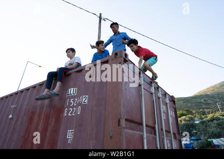 Samos, Samos, Griechenland. 28 Juni, 2019. Kinder spielen auf einem Container auf Samos Die Insel Samos ist eine der migrantischen Europa hotspots als Rezeption und Identifizierung Center (RIC). Es war, als eine vorübergehende Unterkunft, wo Migranten, bevor Sie zu einem Flüchtlingslager auf dem Festland verarbeitet werden könnten. Jedoch aufgrund der anhaltenden Zahl der Ankünfte, das Festland Camps sind voll und so Migranten werden auf den Inseln. Die Bedingungen sind unmenschlicher als die zentrale Regierung hat seit mehreren Jahren ignoriert Anfragen aus der Gemeinde für die Unterstützung für die Insel. (Credi Stockfoto