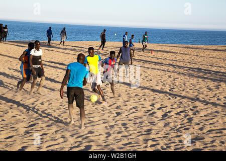 Die afrikanischen Männer am Strand Fußball spielen Stockfoto