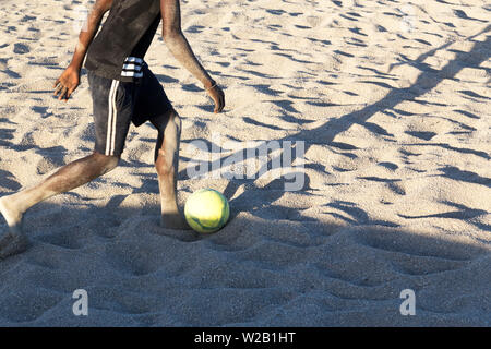 Die afrikanischen Männer am Strand Fußball spielen Stockfoto