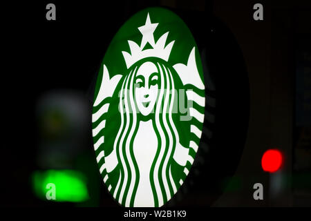 MINNEAPOLIS, Minnesota/USA - Juli 3, 2019: Starbucks Zeichen auf ein Minneapolis Sommernacht mit Straßenbeleuchtung auf Fenster beleuchtet Stockfoto