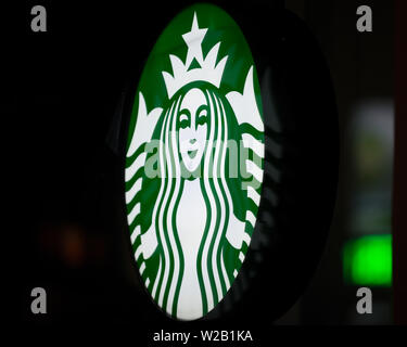 MINNEAPOLIS, Minnesota/USA - Juli 3, 2019: Starbucks Zeichen auf ein Minneapolis Sommernacht mit Straßenbeleuchtung auf Fenster beleuchtet Stockfoto