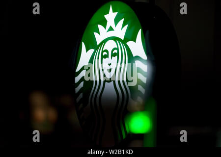 MINNEAPOLIS, Minnesota/USA - Juli 3, 2019: Starbucks Zeichen auf ein Minneapolis Sommernacht mit Straßenbeleuchtung auf Fenster beleuchtet Stockfoto