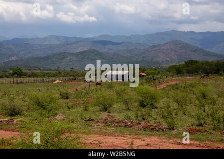 Wunderschöne Aussicht auf eine Farm auf dem Land mit den Bergen im Hintergrund. In der Nähe von Trinidad, Kuba genommen. Stockfoto