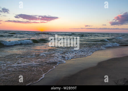 Michigan Sommer Strand Sonnenuntergang Panorama. Sonnenuntergang Horizont spiegelt sich das blaue Wasser des Lake Michigan, wie Wellen am Strand. Hoffmaster State Park Stockfoto