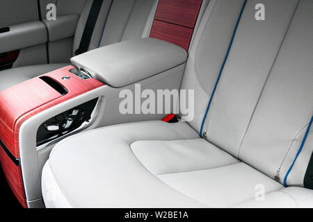 Zurück Sitze in der modernen Luxus Auto. Frontale Ansicht. Weiß perforiertes Leder mit Ziernähten. Von Autoteilen. Leder bequemen weißen Sitze. Auto Stockfoto