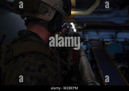 Force Reconnaissance Marines mit maritimen Raid-Kraft, 31 Marine Expeditionary Unit, begeben Sie sich in den Maschinenraum beim Löschen des Schiffes während eines Besuchs, Board, Durchsuchung und Beschlagnahme Übung an Bord der Amphibischen dock Landung Schiff USS Ashland (LSD 48), unterwegs in der Coral Sea, 29. Juni 2019. Ashland, Teil der Wasp amphibischen bereit, Gruppe, mit Eingeschifft 31 MEU, arbeitet in der indopazifischen Region Interoperabilität mit Partnern zu verbessern und dienen als ready-Response Force für jede Art von Kontingenz, und stellen gleichzeitig eine flexible und tödliche Krise Response Force bereit zu perfo Stockfoto