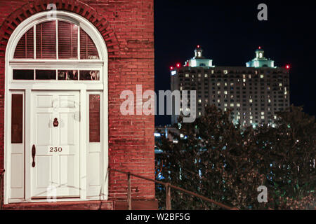 Schöne rote Backsteingebäude in Historic Savannah, Georgia mit einem modernen Gebäude weit im Hintergrund kontrastiert. Stockfoto