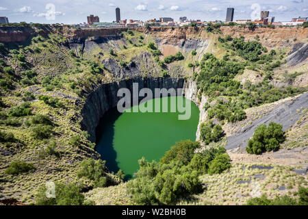 Kimberley, Südafrika, 10. April 2019: Blick auf den Tagebau mit See. Stadt im Hintergrund. Stockfoto