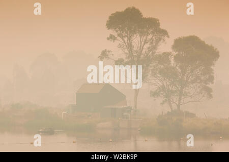 Australien, New South Wales, NSW, Kosciuszko National Park, Thredbo, See Reflexion mit Rauch von Waldbränden, Dämmerung Stockfoto