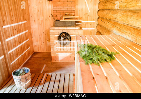 Russische Holz- Sauna Banja mit Besen Fichte und Backofen mit Steinen Stockfoto