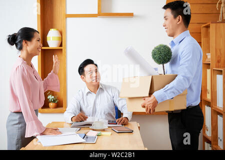 Glückliche junge asiatische Geschäft Leute Gruß Ihre neue, junge Mitarbeiter mit Karton von Sachen im Büro Stockfoto