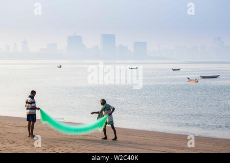 India, Maharashtra, Mumbai, Chowpatty, Männer mit fischernetz am Strand Stockfoto