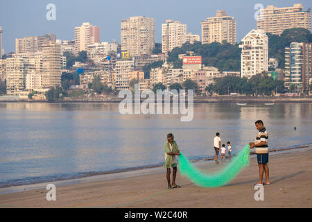India, Maharashtra, Mumbai, Chowpatty, Männer mit fischernetz am Strand Stockfoto