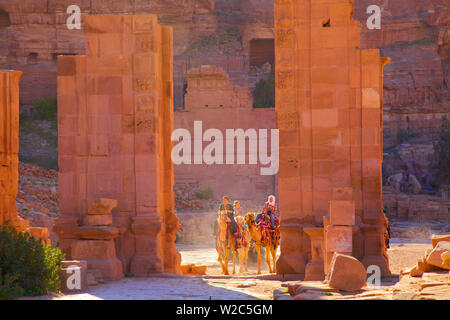 Kamele und Touristen durch die Temenos Tor, Petra, Jordanien, Naher Osten Stockfoto