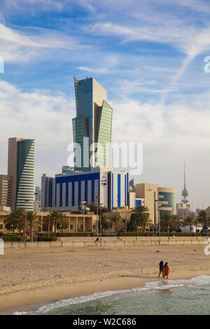 Kuwait, Kuwait City, Sharq, Frauen entlang eine Stadt Strand am Arabischen Golf Straße mit Stadtzentrum Gebäude Stockfoto