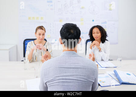 Ansicht der Rückseite des Unternehmer sitzen am Tisch und hören auf Berichte der Leiter der Abteilungen Stockfoto