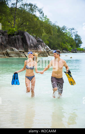 Paar hält Flipper laufen am Strand, Mahe, Seychellen Stockfoto