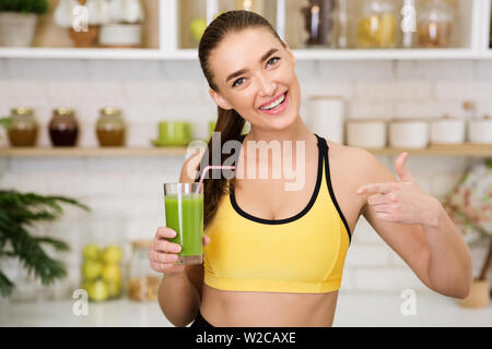 Schlanke Frau zeigt auf Glas Spinat smoothie Stockfoto