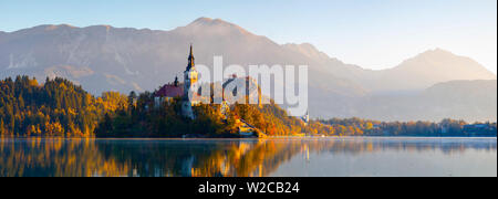 Die Insel (Blejski otok) mit der Kirche Mariä Himmelfahrt (Cerkev Marijinega vnebovzetja) & Burg von Bled beleuchtet bei Sonnenaufgang, der See von Bled, Bled, Obere Krain, Julische Alpen, Slowenien Stockfoto