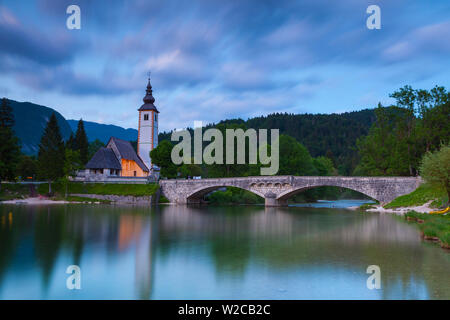 Bohinjer See & die Kirche St. Johannes der Täufer leuchtet in der Dämmerung, Nationalpark Triglav, Slowenien Stockfoto