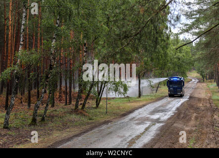 Alt Jabel, Deutschland. 08 Juli, 2019. Die Polizei Wasserwerfer löscht einzelne leuchtende Nester im Wald auf dem ehemaligen Truppenübungsplatz. Eine Woche nach dem Ausbruch der verheerenden Waldbrand in der Nähe von Lübtheen im südwestlichen Mecklenburg, die Flammen in der Gegend, die stark mit Munition verunreinigt, haben gelöscht, nach dem Befehl. Auf einer Fläche von etwa 500 Hektar, es gibt noch glühende Nester im Boden, sind genau zu beachten. Insgesamt 1.200 Hektar Wald waren betroffen. Credit: Jens Büttner/dpa-Zentralbild/dpa/Alamy leben Nachrichten Stockfoto