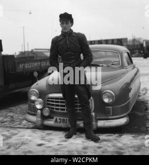 Der Motorradfahrer in den 1950er Jahren. Ein junger Mann, der in der typischen Art und Weise der Motorradfahrer in den 1950er Jahren tat gekleidet. Alle Leder. Leder Stiefel, Hose und Jacke. Einen nierengurt und ein typisches Motorradfahrer cap. Schweden Dezember 1954 Stockfoto