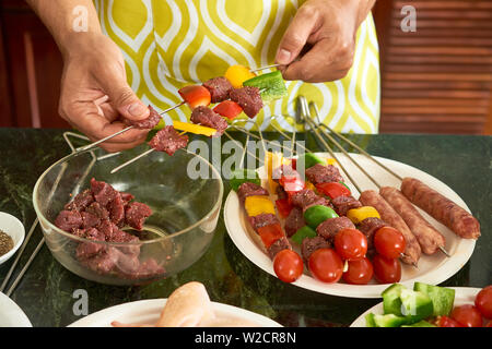 Close-up des Menschen kochen Kebab mit Rindfleisch und frische Gemüse am Küchentisch für Grill Stockfoto