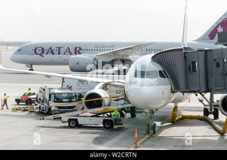 Hamad International Airport, Doha, Katar 2018-05-01: Zwei airline Flugzeuge am Flughafen. Jetway auf das Flugzeug, Vorderansicht. Der Arbeitstag am Flughafen Stockfoto