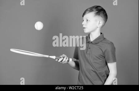 Träumen über Sport Karriere. Athlet kid Tennisschläger auf blauem Hintergrund. Tennis Sport und Unterhaltung. Junge Kind Tennis spielen. Tennis Fähigkeiten zu üben. Kerl mit Schläger genießen Spiel. Zukünftige Meister. Stockfoto