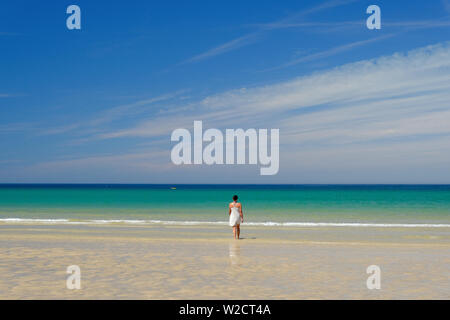 Eine Frau, die zu Fuß ins Meer auf godrevy Beach, Cornwall Stockfoto