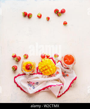 Gesunde Früchte und Beeren frühstück Hintergrund. Gläser mit Erdbeeren und Mango Smoothies auf weißer Tisch. Platz kopieren Stockfoto