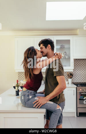 Liebevolle junge Paar zusammen in der Küche zu Hause. Paare, die in Liebe zu Hause zu küssen. Stockfoto