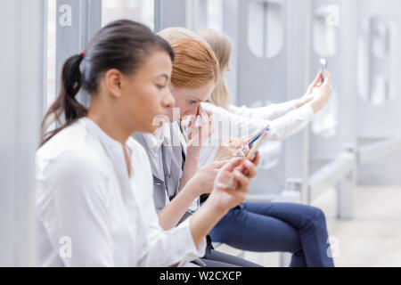 Geschäft Leute an Bruch mit Handys das Surfen im Netz und unter selfie Stockfoto