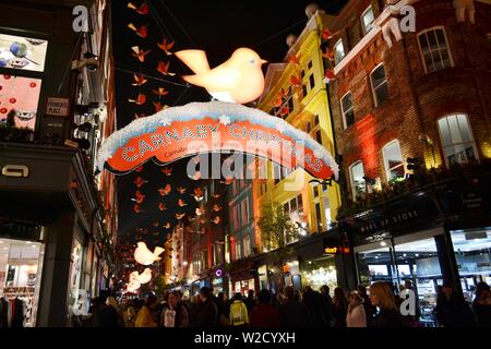 London/Großbritannien - 28. November 2013: Carnaby Street in London für Weihnachten mit roten Fahnen und Vögel gehalten, was die Wahrnehmung mehr glücklich. Stockfoto