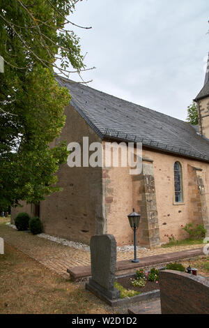 Kirche St. Peter in Roth an der Our, Deutschland - eine ehemalige Kirche der Tempelritter, teilweise Sommer Außenansicht unter dramatischen bewölkten Himmel Stockfoto