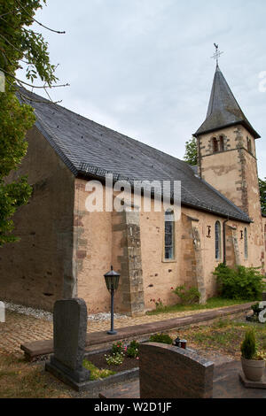 Kirche St. Peter in Roth an der Our, Deutschland - eine ehemalige Kirche der Tempelritter, teilweise Sommer Außenansicht unter dramatischen bewölkten Himmel Stockfoto