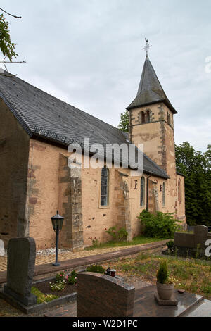 Kirche St. Peter in Roth an der Our, Deutschland - eine ehemalige Kirche der Tempelritter, teilweise Sommer Außenansicht unter dramatischen bewölkten Himmel Stockfoto