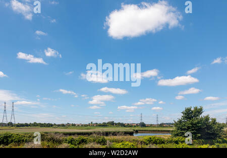 Blick über Schilf des Flusses Test Mündung in Redbridge beim Eintritt in Southampton Wasser in Richtung Totton mit Strommasten und Leitungen Stockfoto