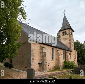 Kirche St. Peter in Roth an der Our, Deutschland - eine ehemalige Kirche der Tempelritter, teilweise Sommer Außenansicht unter dramatischen bewölkten Himmel Stockfoto