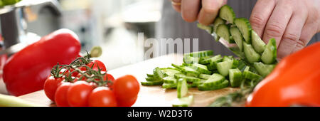 Professioneller Koch Hand Zerkleinern frische Gurke Stockfoto