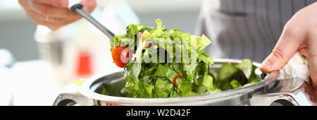 Männliche Hände mischen Organische gehackt Salat Stockfoto