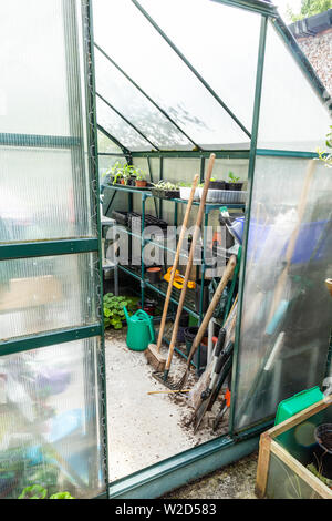 Durch eine offene Tür Gewächshaus Garten Werkzeuge und Anlagen zu sehen. Stockfoto