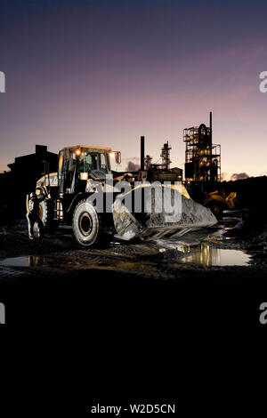 Abbau, Verwaltung und Transport von mineralischen Sanden aus Titan. Frontlader, der schweres mineralisches Sandkonzentrat vom Vorratstapel zum Trennwerk verschiebt. Stockfoto