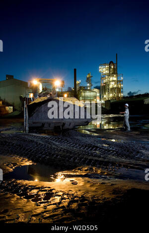 Abbau, Verwaltung und Transport von mineralischen Sanden aus Titan. Frontlader, der schweres mineralisches Sandkonzentrat vom Vorratstapel zum Trennwerk verschiebt. Stockfoto