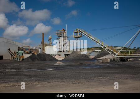 Bergbau, Verwaltung und Transport von Titanmineralsanden. Frontlader hinter dem Bewegen von schwerem Mineralsandkonzentrat aus dem Lagerstapel in den Trichter Stockfoto