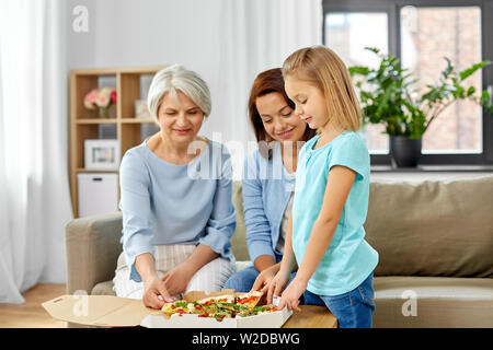 Mutter, Tochter und Großmutter essen Pizza Stockfoto