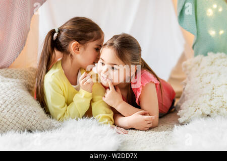 Glückliche Mädchen in Kinder Zelt liegen und sprechen zu Hause Stockfoto