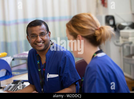 Zwei Krankenschwestern an eine Arbeitsstation in einem NHS Station in einem Krankenhaus Stockfoto