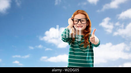 Rothaarige Schüler Mädchen in Gläsern über blauen Himmel Stockfoto