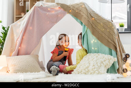 Mädchen, die mit einer Fackel in der Kinder Zelt zu Hause Stockfoto